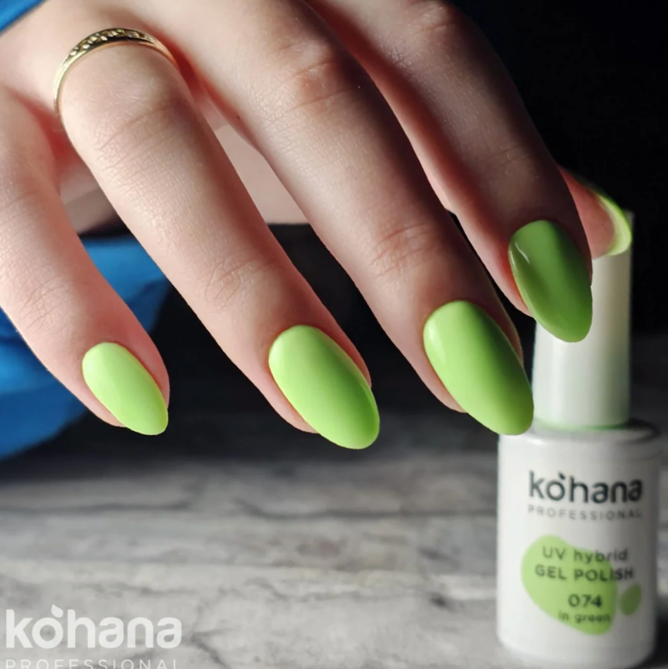 Hand with green nail polish holding a bottle of Kohana gel polish.