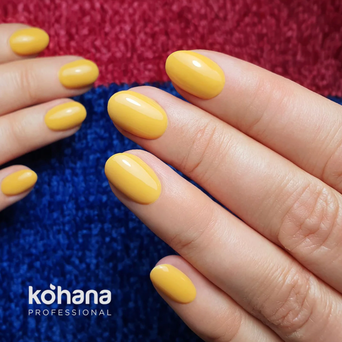 Close-up of hands with yellow nail polish on a textured red and blue background, Kohana Professional branding visible.